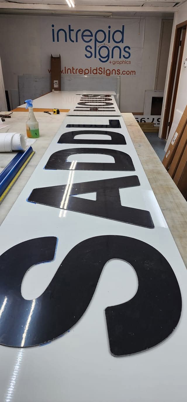 Large cut letters spelling SADDLE in the shop — Intrepid Signs, Rosenberg TX