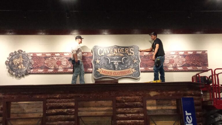 Retail interior, team banner display being installed on a wall — Intrepid Signs, Rosenberg TX